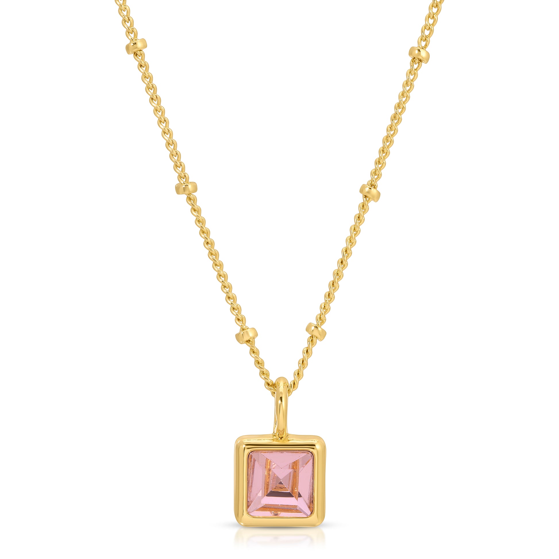A gold necklace with a pink square pendant.