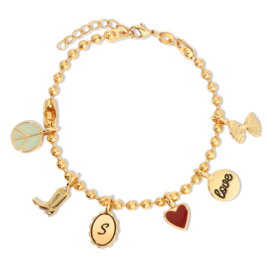 A gold-colored charm bracelet with various charms, including a peace sign, cowboy boot, 'S' pendant, heart, and 'love' coin, is displayed on a black background.