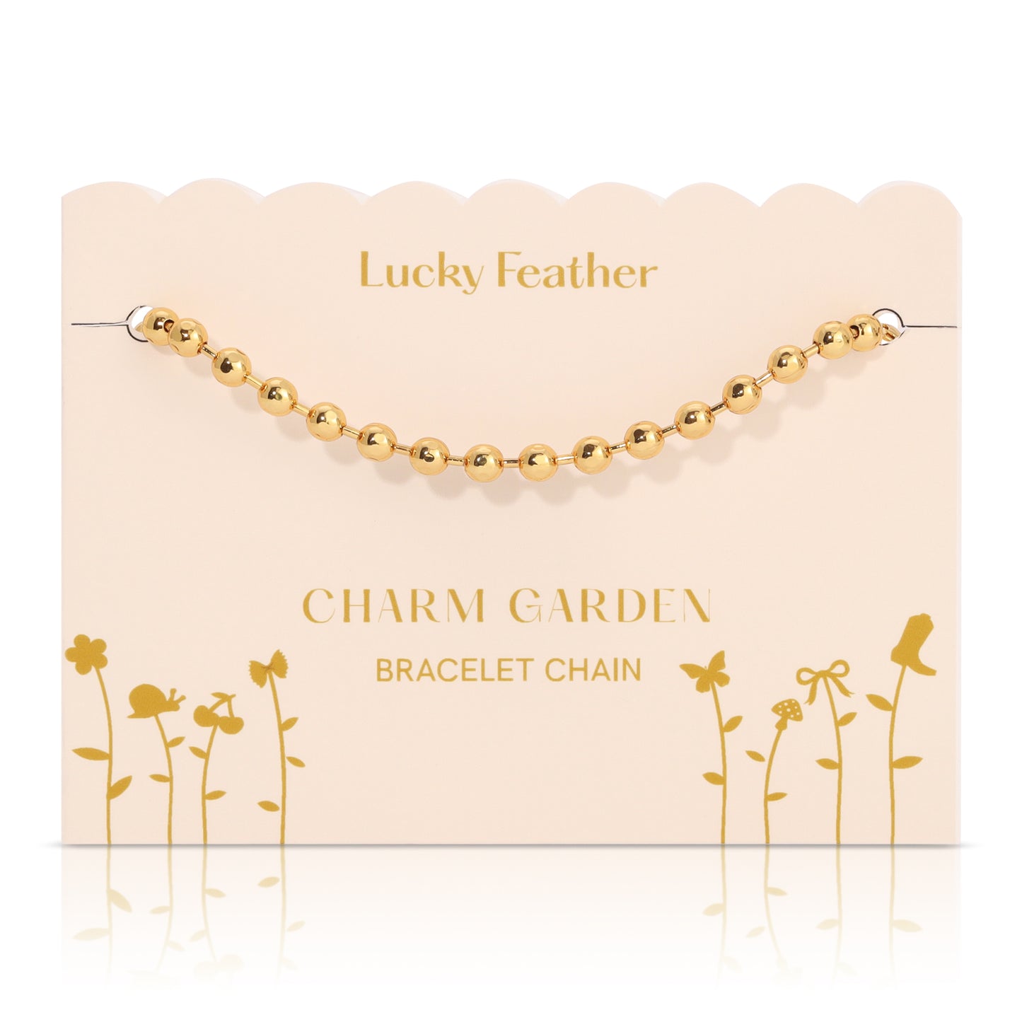 A gold bead bracelet chain on a decorative "Lucky Feather Charm Garden" display card.