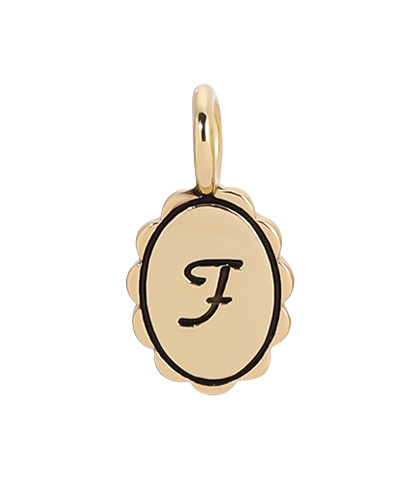 A gold charm with an oval face and a cursive "F".