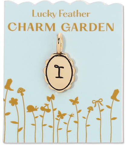 A gold letter "I" charm hangs from a card labeled "Lucky Feather CHARM GARDEN" with a flower and boot illustration.