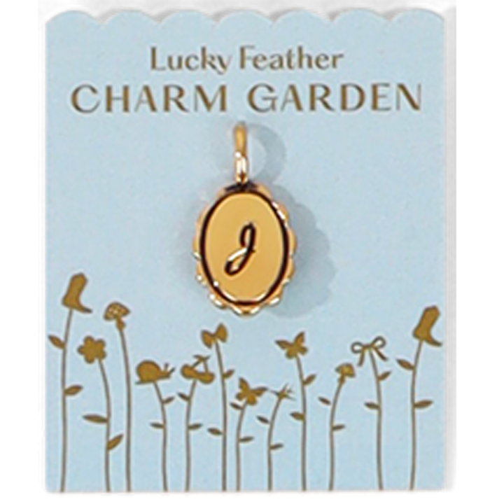 The image shows a gold-colored pendant with the letter 'J' on a light blue 'Lucky Feather CHARM GARDEN' card decorated with floral designs.