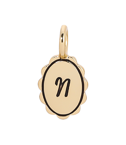 A gold charm with the letter "n" in black.