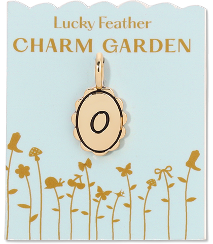 A gold-colored "O" charm on a "Lucky Feather Charm Garden" card with a pale blue background.