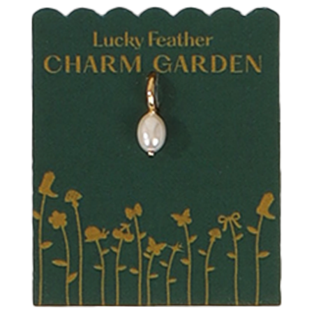A pearl charm on a "Lucky Feather Charm Garden" card with gold flower illustrations.