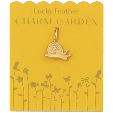 A gold snail charm hangs on a yellow 'Lucky Feather Charm Garden' display card.