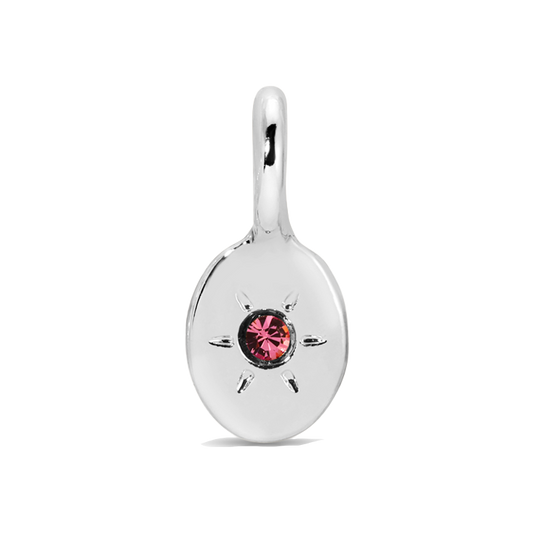 A silver pendant with a pink gem in a starburst setting.