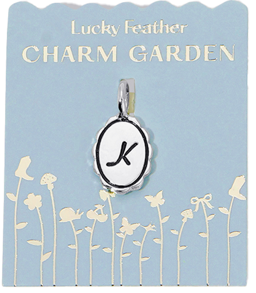 Oval charm pendant with a letter "K" on a blue card labeled "Lucky Feather Charm Garden".
