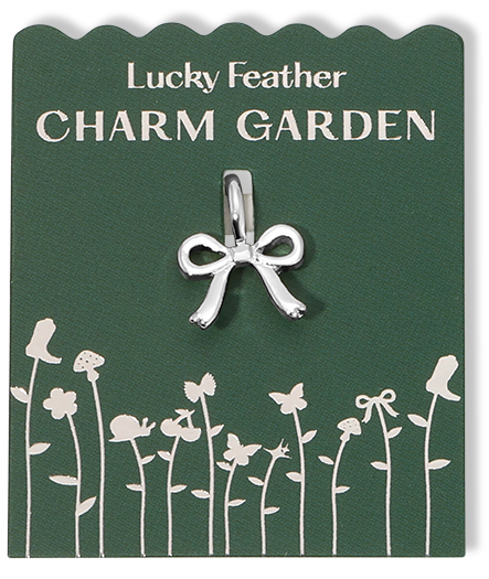 The image shows a 'Lucky Feather Charm Garden' tag with a silver bow charm attached.