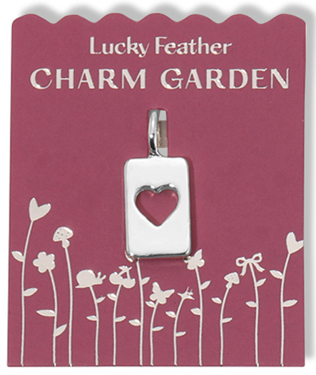 A silver heart charm pendant on a pink "Lucky Feather Charm Garden" card with floral designs.