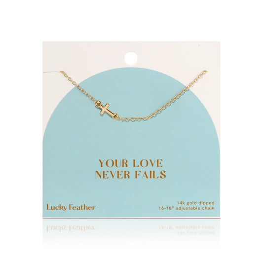 A 14k gold-dipped necklace with a cross pendant on a display card that reads 'Your Love Never Fails.'