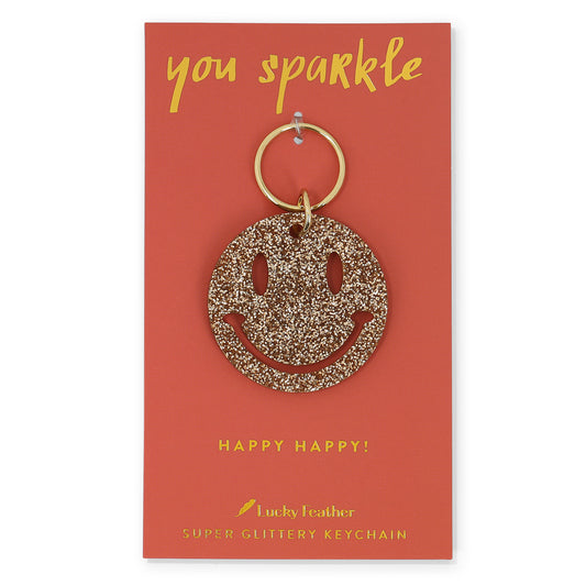 You sparkle card with a glittery gold smiley face keychain.