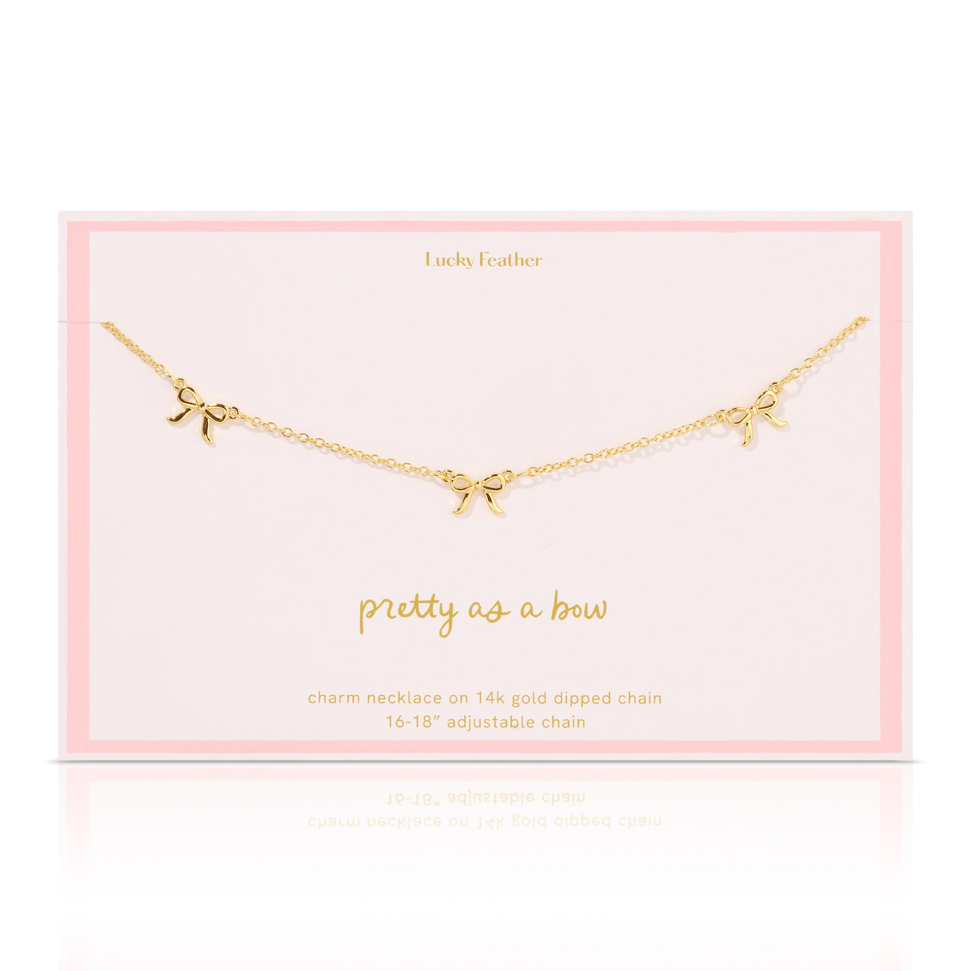 A gold charm necklace with three bows displayed on a pink card that says "Lucky Feather".