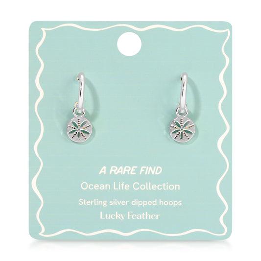 Two silver hoop earrings with sand dollar charms are displayed on a blue-green product card.