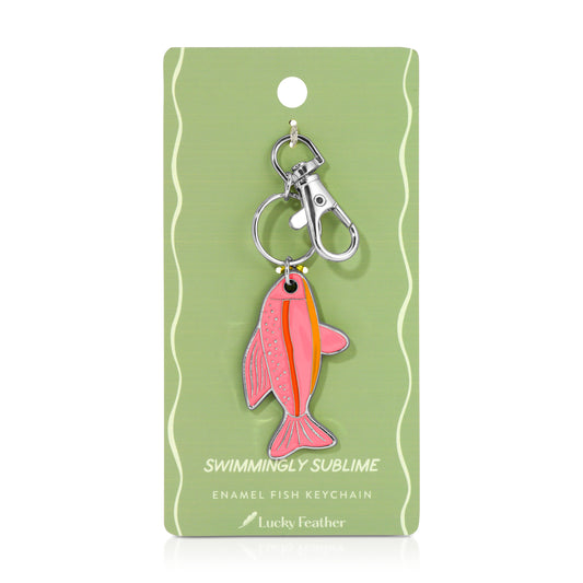 A pink fish keychain hangs on a green display card.