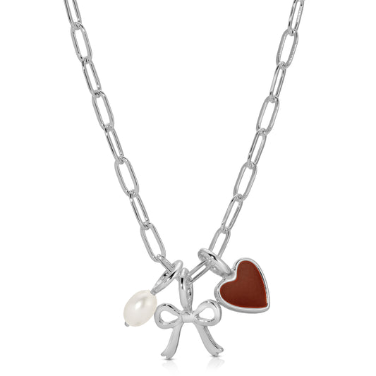 A silver chain necklace with a pearl, silver bow, and brown heart charm is displayed.