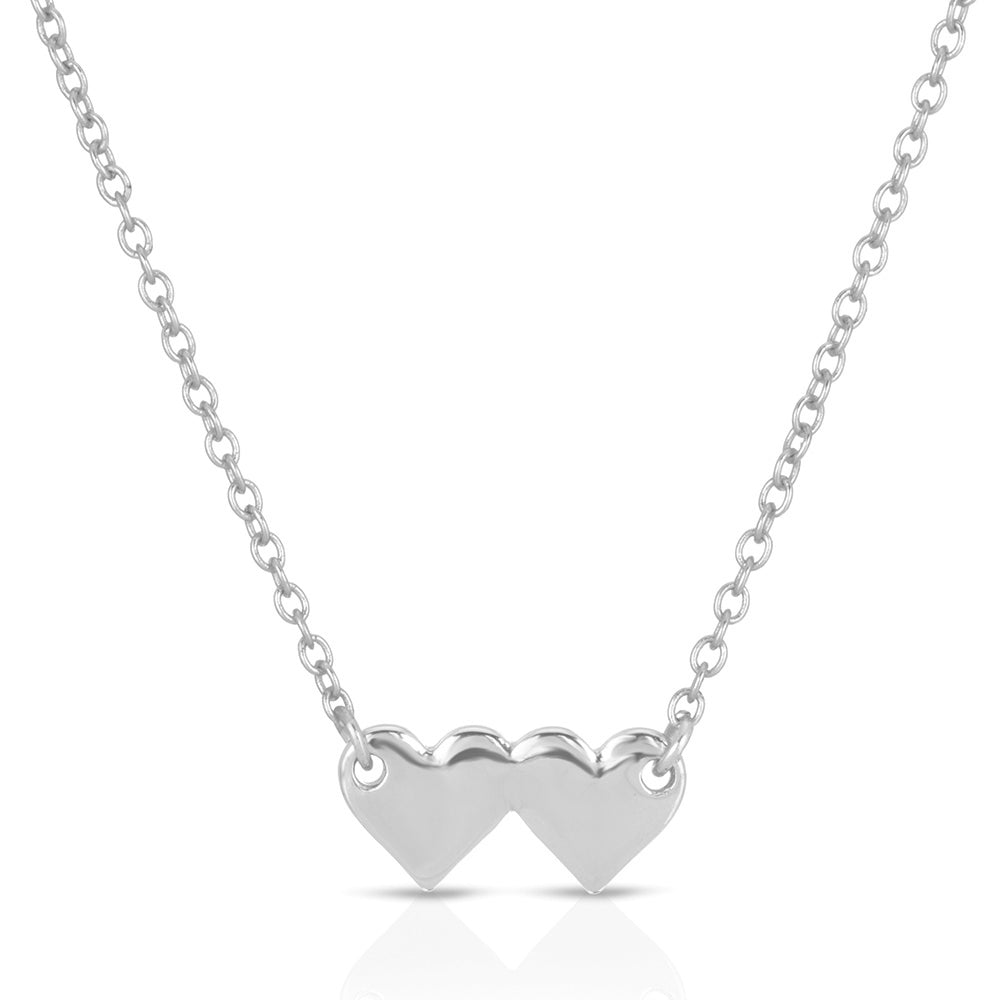 A silver necklace features two adjacent heart pendants.