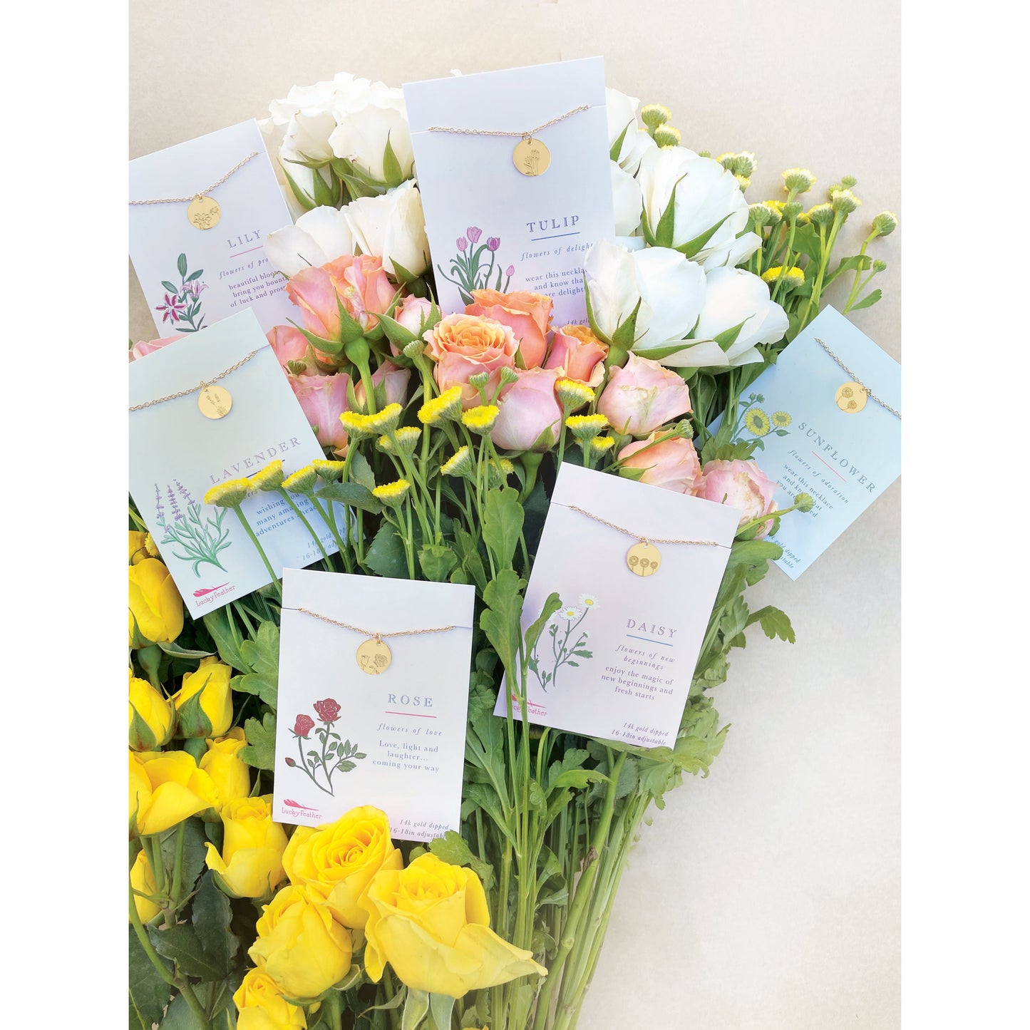 A bouquet of flowers with flower-themed necklaces displayed on cards.
