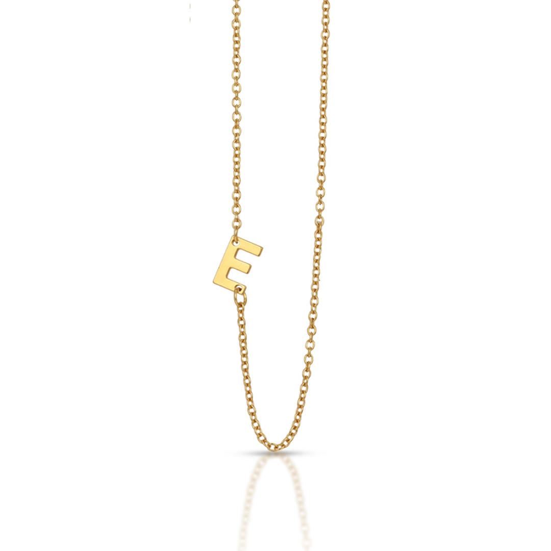 A gold necklace features the letter "E" as a pendant.
