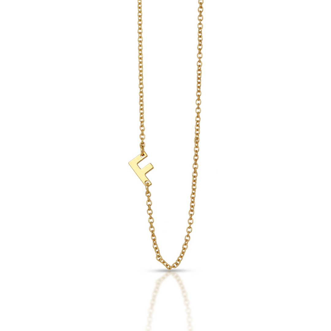 A gold chain necklace features a letter F charm.