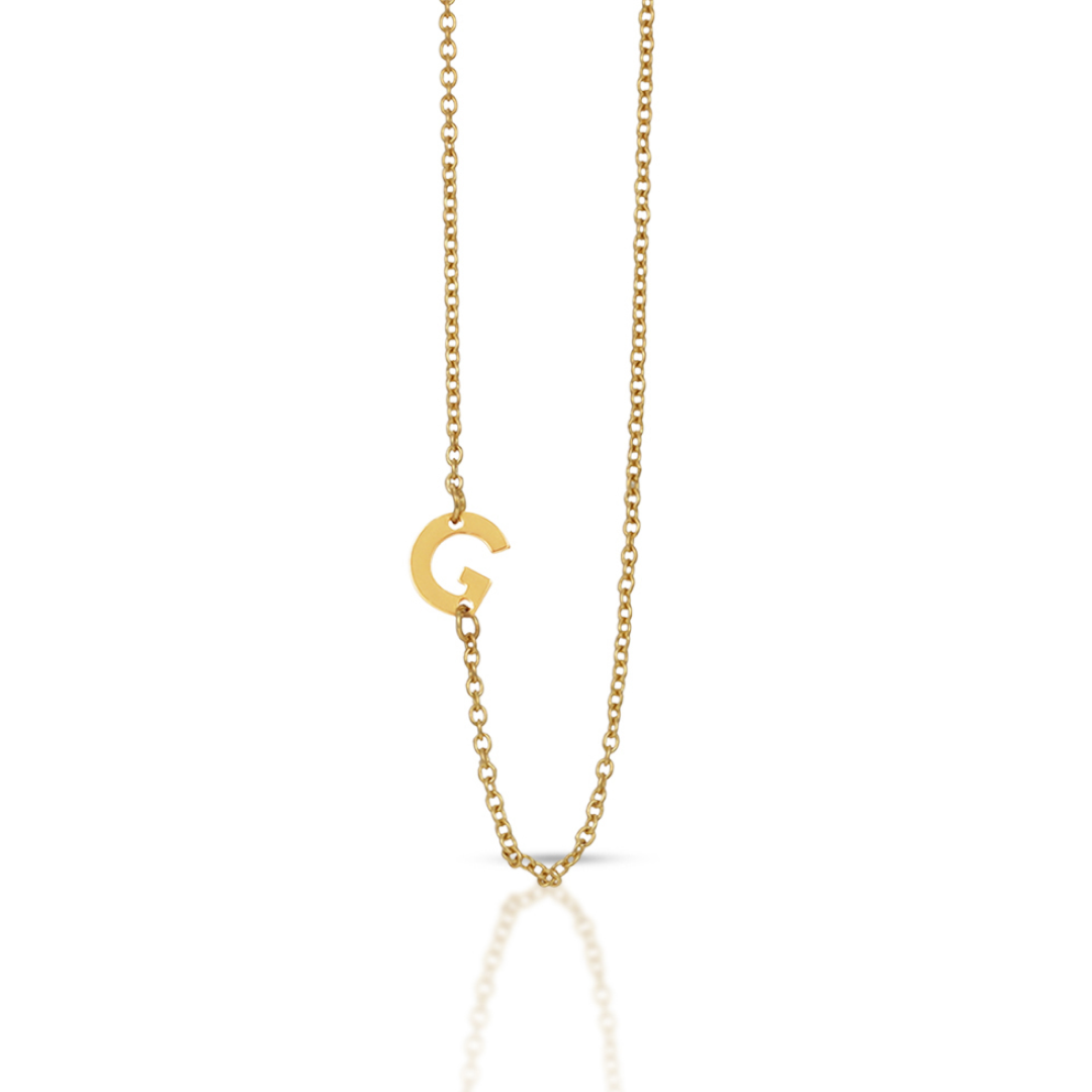A gold chain necklace features a sideways initial "G" pendant.