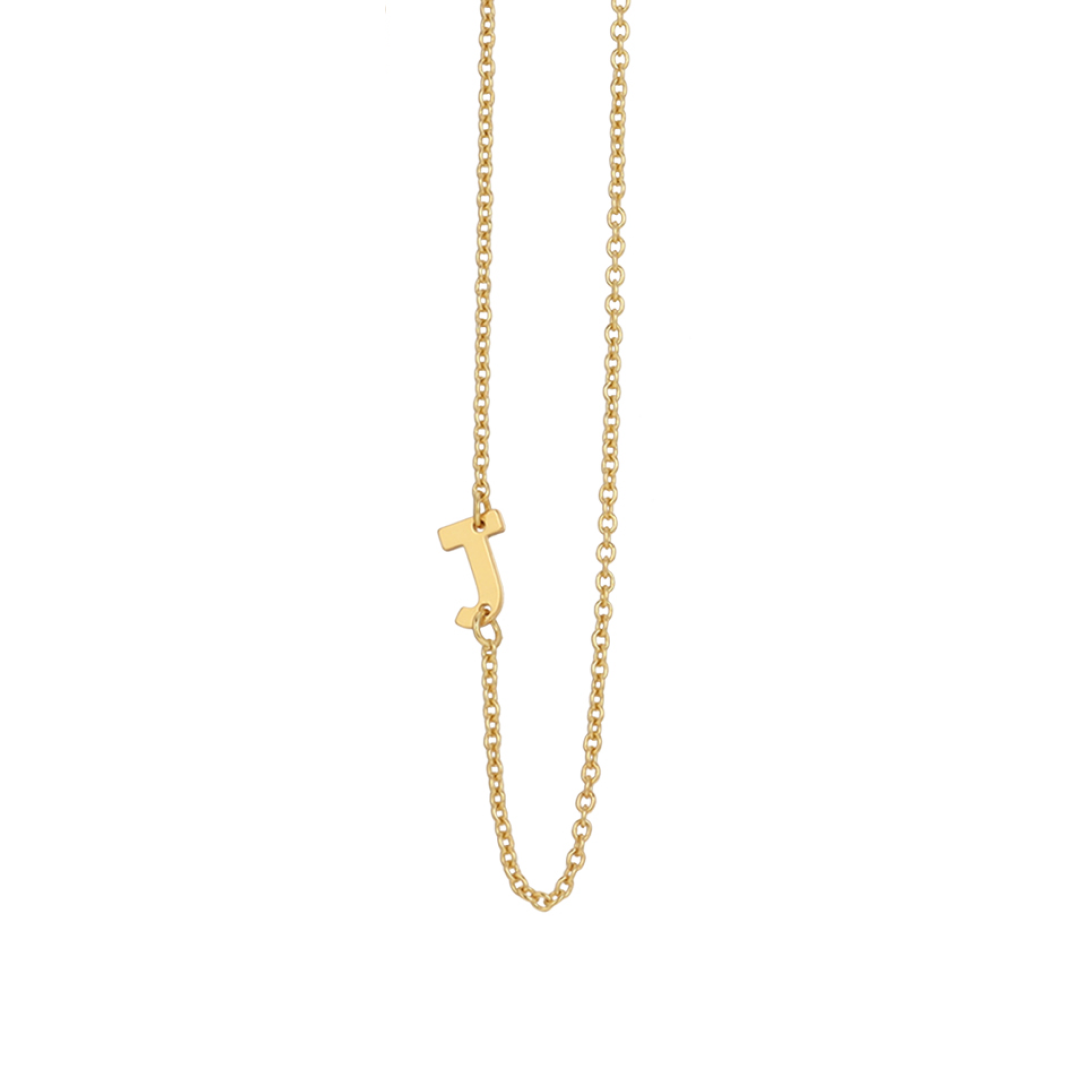 A gold necklace hangs with a letter J pendant.