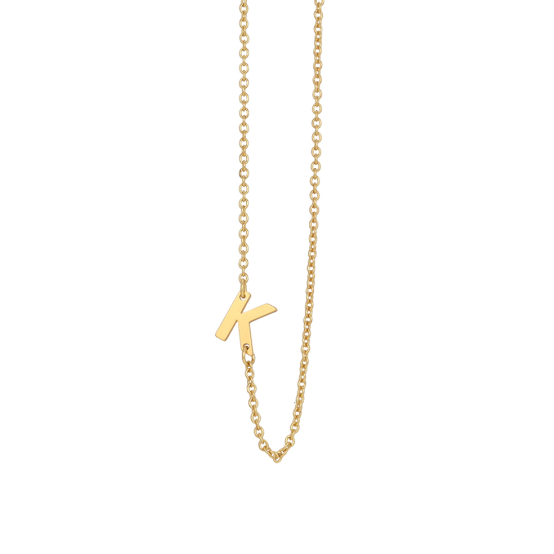 A gold necklace features the letter K.