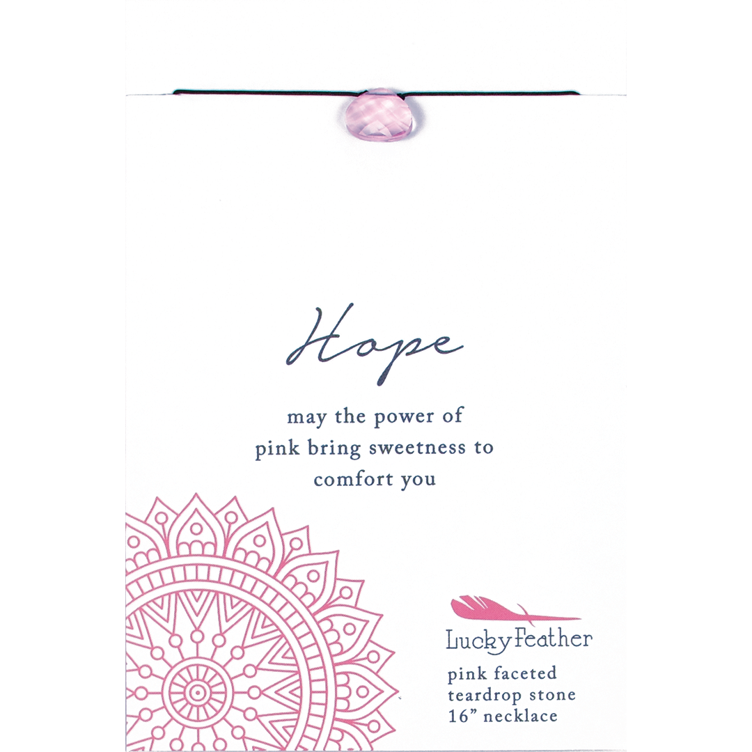 Close-up of a necklace with a pink faceted teardrop stone labeled "Hope" on a card with inspirational text.
