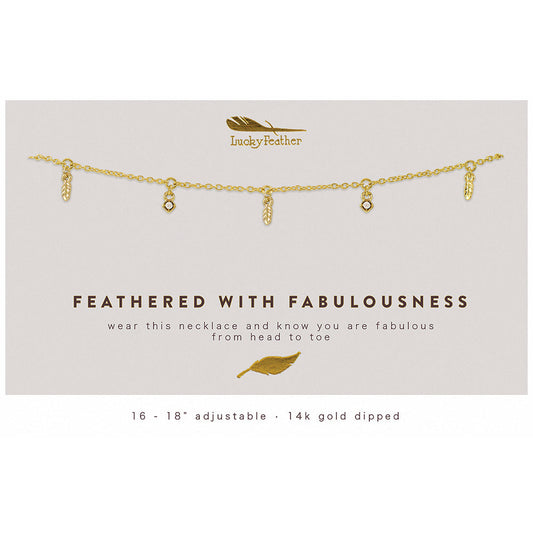 A 14k gold dipped necklace with feather and gem pendants on a display card.