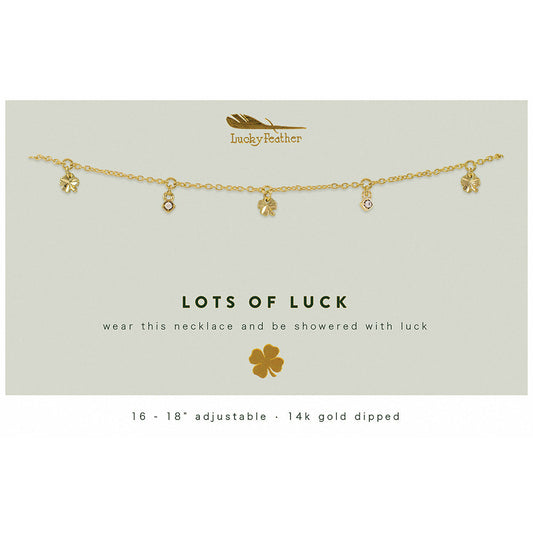 A gold-colored necklace with clover and jewel charms is displayed on a card that reads 'Lots of Luck'.
