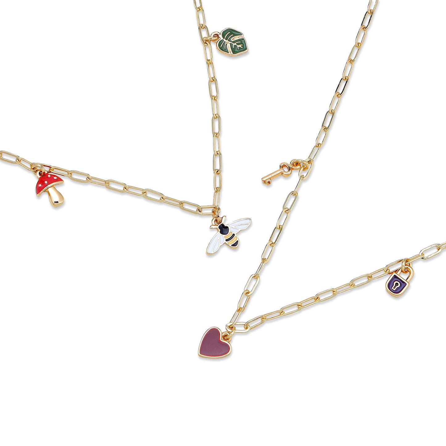 Several gold chain necklaces with enamel charms including a mushroom, leaf, bee, key, heart, and padlock, on a white background.