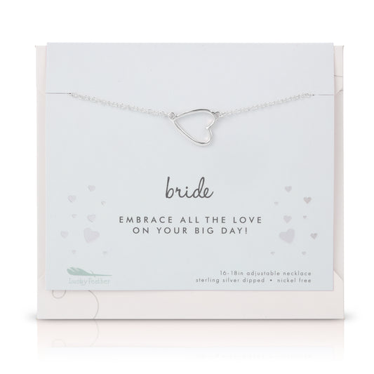 A silver heart pendant necklace on a 'Bride' card from Lucky Feather.