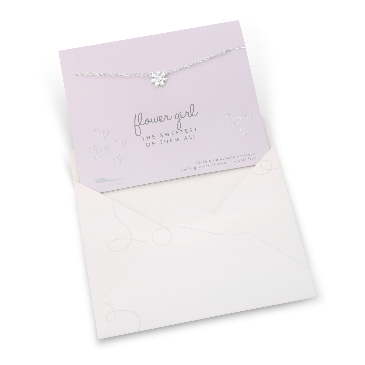 A silver flower necklace sits atop a lavender card in an open, white envelope.