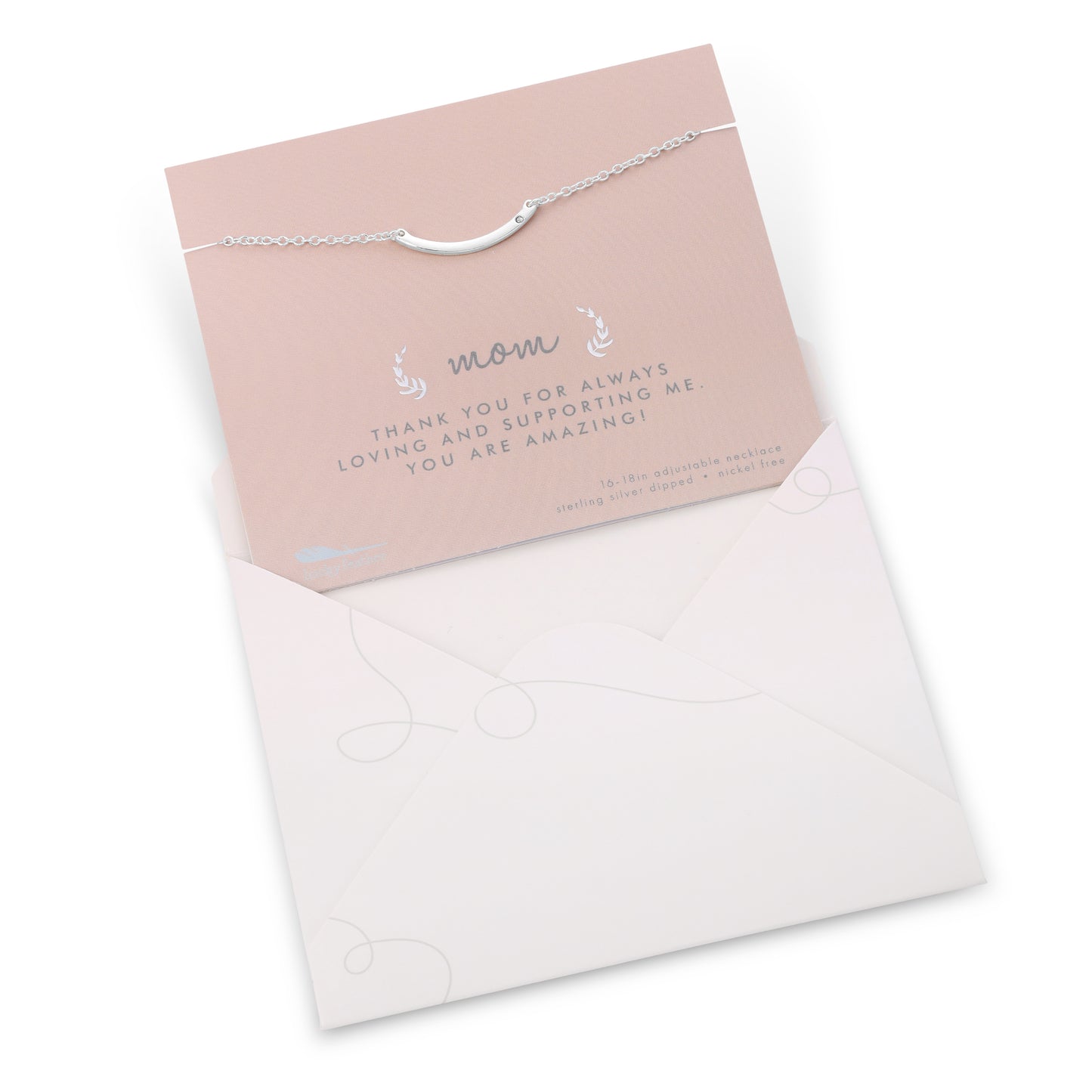 A silver necklace on a pink card with "Mom" printed on it is partially enclosed in a white envelope.