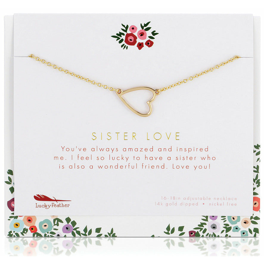 A gold-colored heart pendant necklace labeled "Sister Love" is displayed on a floral-themed card.