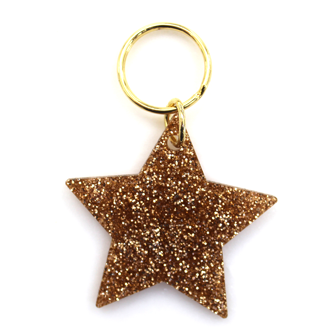 A gold glitter star-shaped keychain on a white background.
