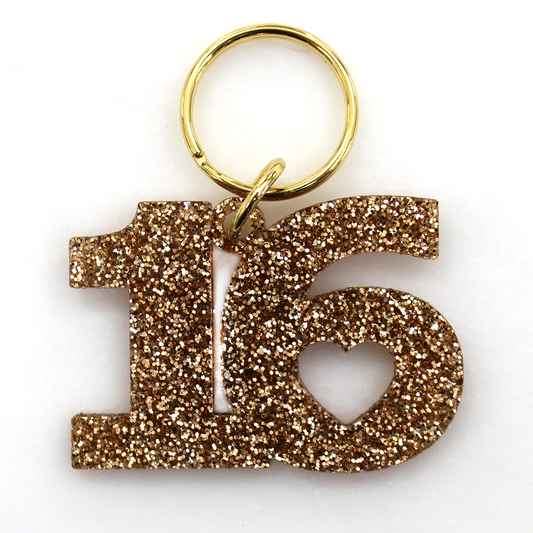 Gold glitter '16' keychain on a white background.