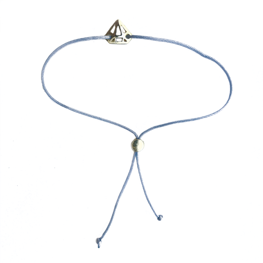 A light blue cord bracelet features a diamond-shaped gold accent.
