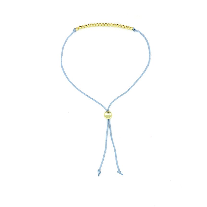 A light blue cord bracelet features gold beads and a sliding closure.