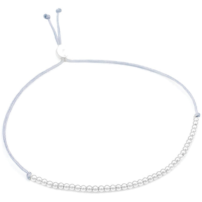 Silver beaded bracelet with adjustable gray cord.