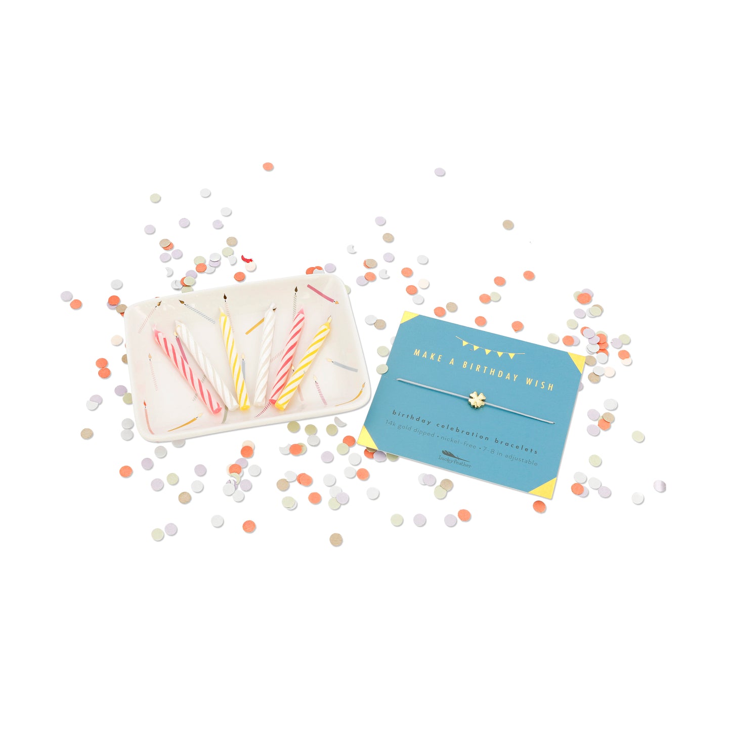 Birthday candles on a tray and a bracelet card with confetti.