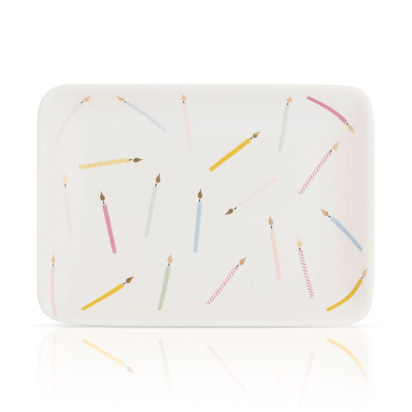 Rectangular white dish decorated with candle illustrations, seen at an angle with a reflective surface below.