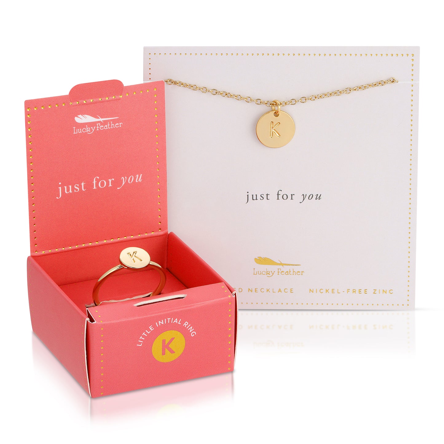 A gold-tone "K" initial ring in a pink box and a gold-tone "K" initial necklace on a white card from "Lucky Feather".