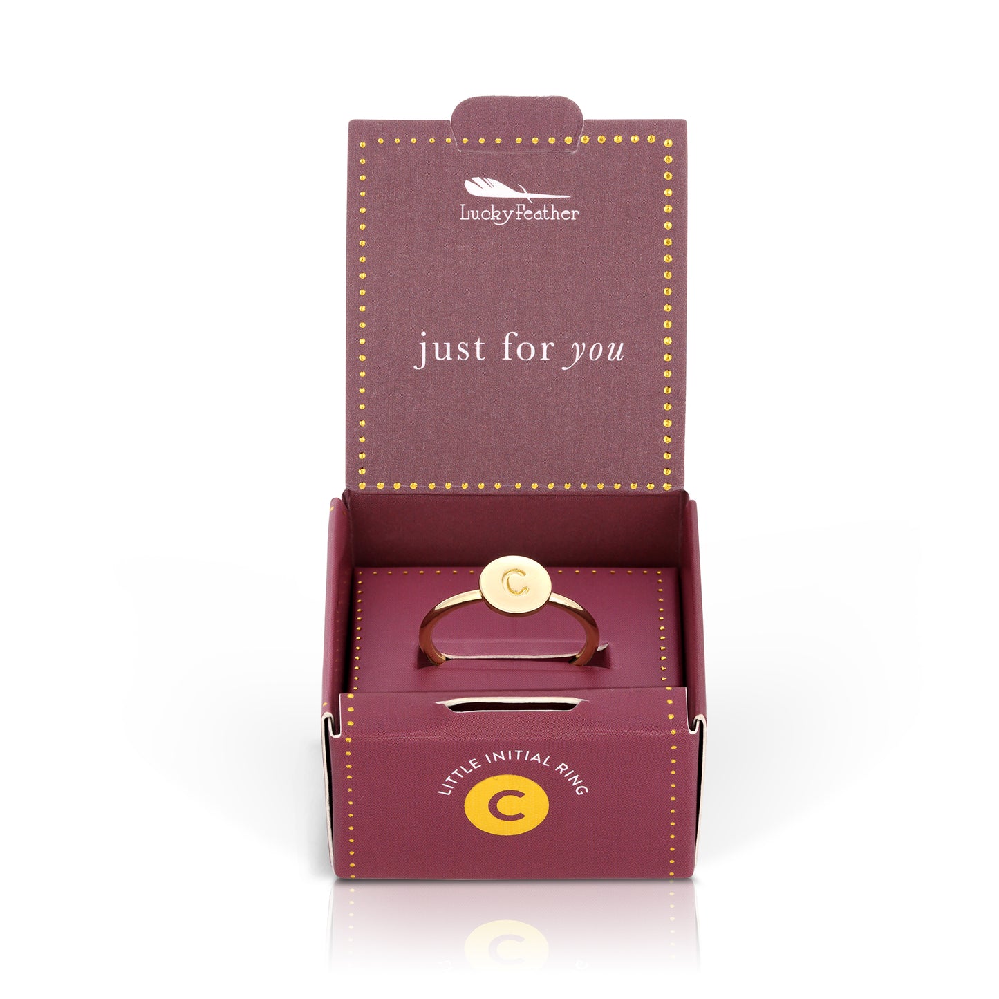 Open "Lucky Feather" gift box with a gold ring bearing the letter "C".