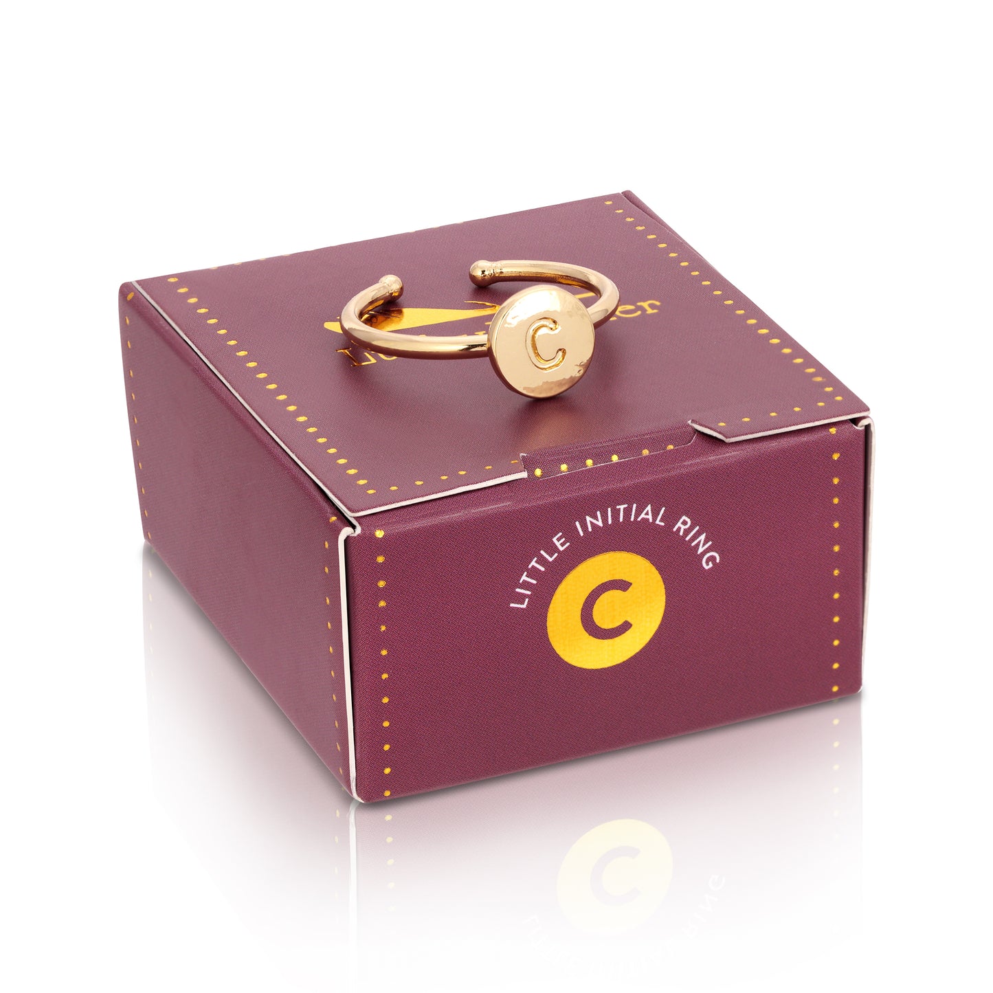 A gold ring with the letter "C" rests on a purple box with the phrase "LITTLE INITIAL RING."