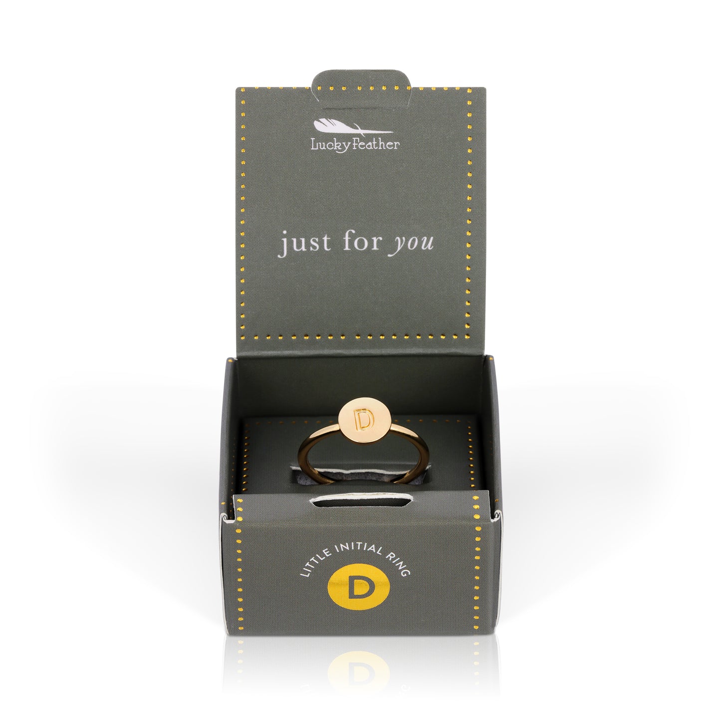 A gold ring with the letter "D" on a round face, displayed in an open gray and gold gift box.