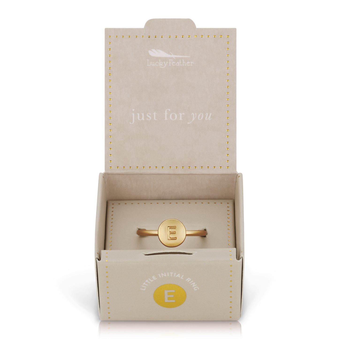 A gold "E" initial ring is inside of an open "Lucky Feather" gift box.