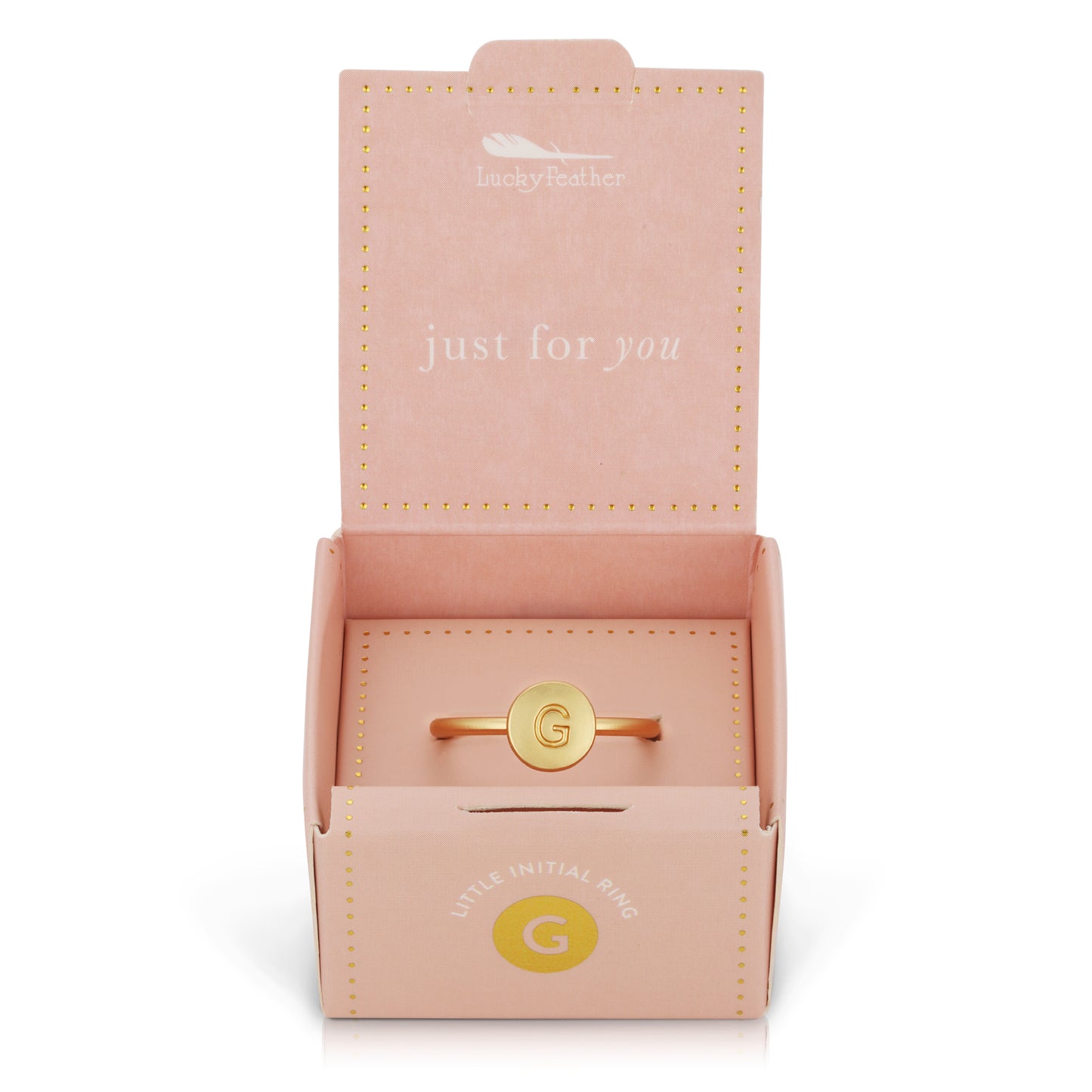 A gold ring with the initial "G" inside a pink "Lucky Feather" gift box.