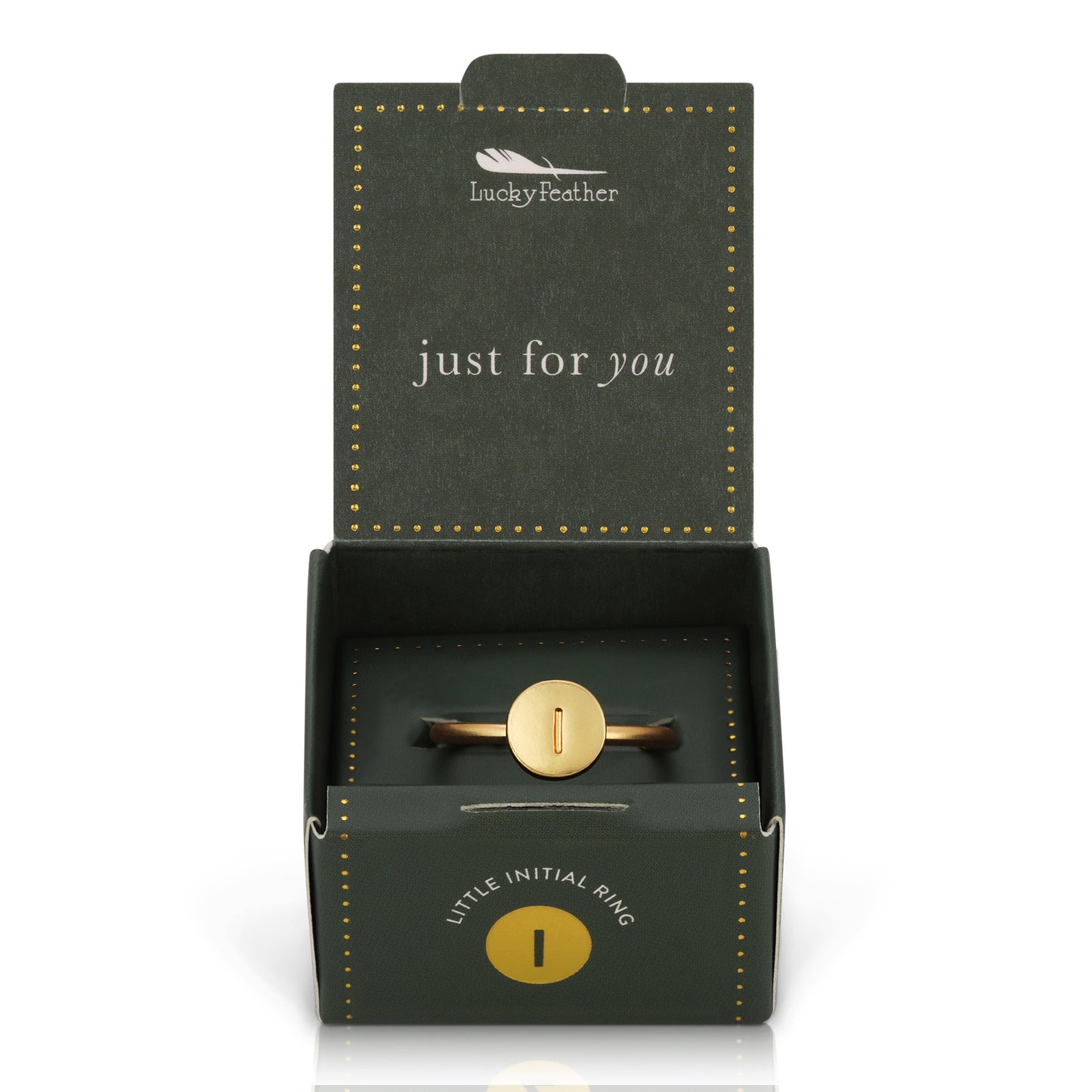 An open gift box displays a gold-colored initial "I" ring.