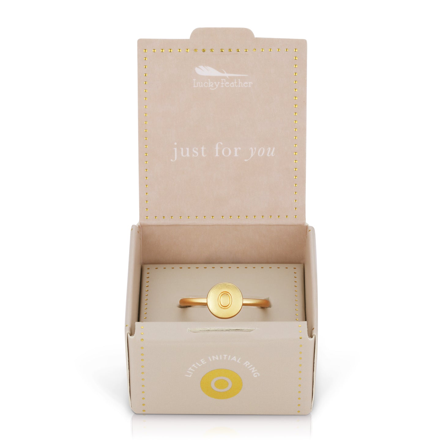 A gold-colored ring with the letter "O" on a round face, presented in an open, beige "Lucky Feather" jewelry box.
